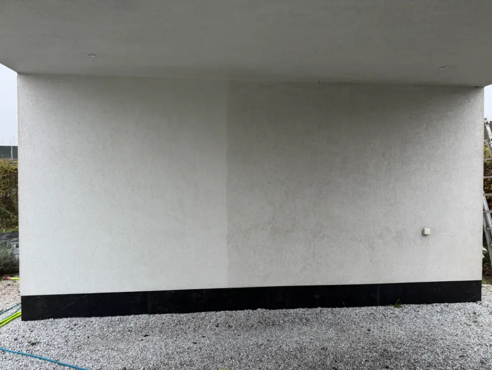 Gedeeltelijk gereinigde crepigevel met zichtbaar verschil tussen vervuilde en schone zijde