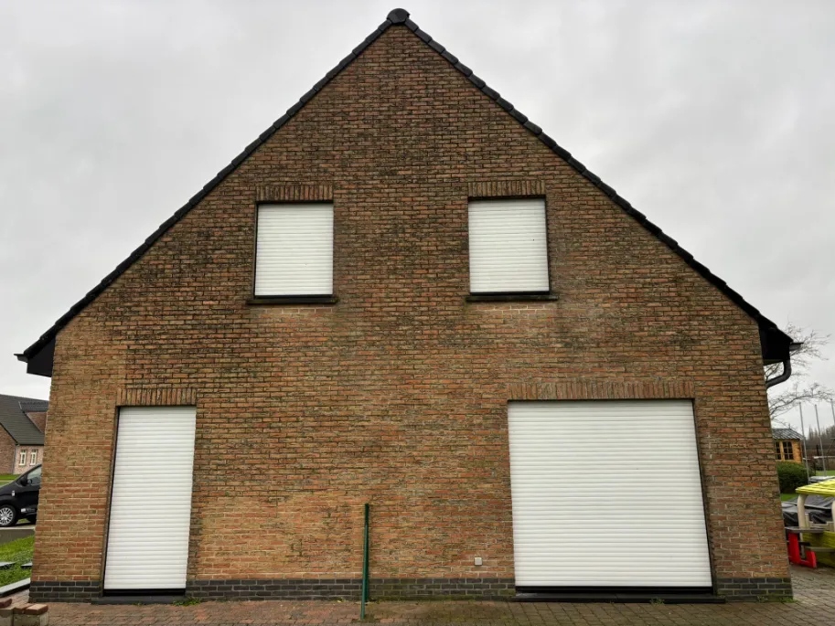 Bakstenen gevel voor reiniging met zichtbare vervuiling en verkleuring