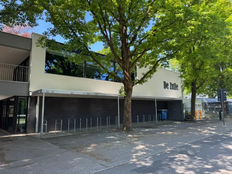 Gebouw De Zulle met groene bomen voor de ingang na gevelreiniging door mos reinigingsservice